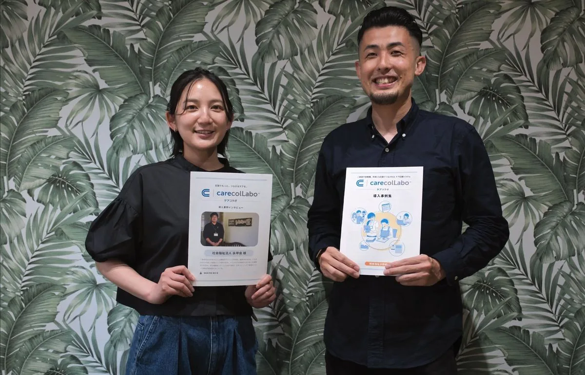 ケアコラボ株式会社の佐藤ありさ様と、制作した導入事例の冊子を手にした岡部拓哉